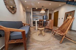 a living room with a couch and chairs and a table at The Teodoro in Tulum