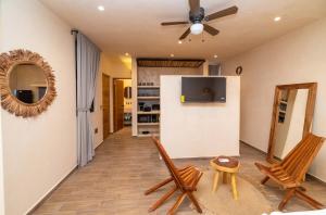 a living room with two chairs and a ceiling fan at The Teodoro in Tulum