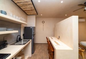 a kitchen with a sink and a refrigerator at The Teodoro in Tulum