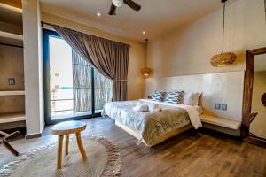a bedroom with a bed and a large window at The Teodoro in Tulum