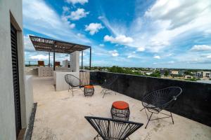 a balcony with chairs and a view of the city at The Teodoro in Tulum