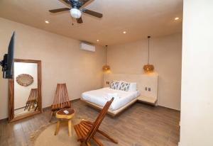 a bedroom with a bed and a ceiling fan at The Teodoro in Tulum