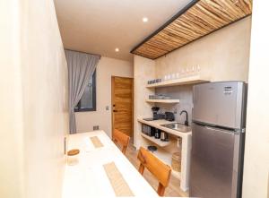 a kitchen with a table and a refrigerator at The Teodoro in Tulum