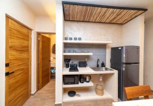 a small kitchen with a refrigerator and a sink at The Teodoro in Tulum