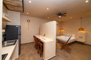 a kitchen with a table and a bed in a room at The Teodoro in Tulum