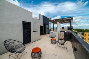 a patio with three chairs and awning on a building at The Teodoro in Tulum