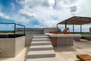 a patio with a bench and stairs on a roof at The Teodoro in Tulum