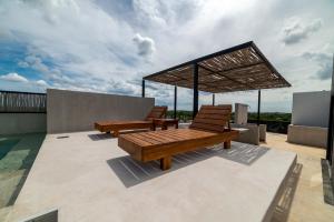two wooden benches on the roof of a house at The Teodoro in Tulum