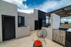 a modern house with a chair on a patio at The Teodoro in Tulum