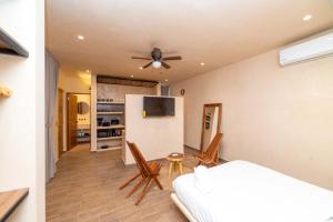 a bedroom with a bed and a flat screen tv at The Teodoro in Tulum
