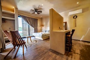 a room with a bed and a table and chairs at The Teodoro in Tulum