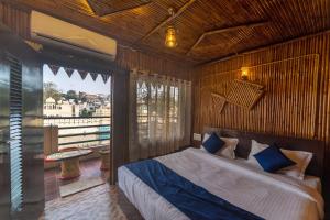 - une chambre avec un lit et une grande fenêtre dans l'établissement Venice View Hotel & Restaurant, à Udaipur