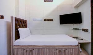a bedroom with a bed with a tv on the wall at ZEST STAYS - MEADOW INN 1058 in Mumbai
