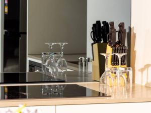 a kitchen counter with wine bottles and wine glasses at Comfort Two bedroom Apartment In Lyneham in Canberra