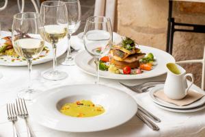 a table with plates of food and glasses of wine at Hotel Rural Biniarroca - Adults Only in Sant Lluis