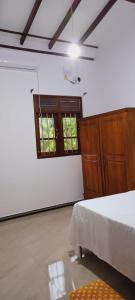 高爾的住宿－One bedroom upstair villa rent, near the Pinnaduwa interchange，客房设有床、橱柜和窗户。