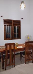 高爾的住宿－One bedroom upstair villa rent, near the Pinnaduwa interchange，餐桌,配有两把木椅和一张桌子及窗户