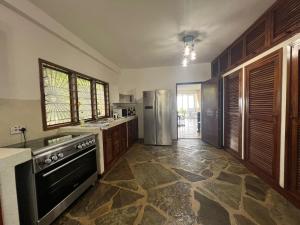 a kitchen with a stove and a refrigerator at BEACH FRONT VILLA in Malindi