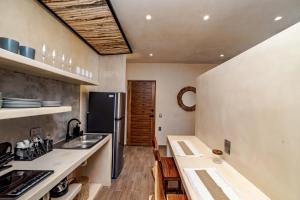 a kitchen with a sink and a refrigerator at The Teodoro in Tulum