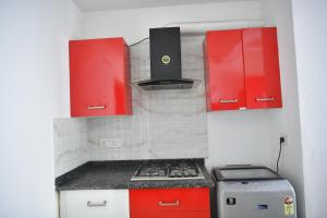 - une cuisine avec des placards rouges et une cuisinière dans l'établissement Aquavista lake view apartment, à Trivandrum
