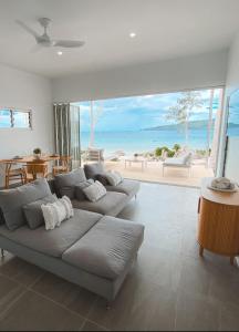 een woonkamer met een bank en uitzicht op de oceaan bij M Resort & Spa in Port Vila