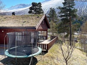 uma pequena casa com um parque infantil em frente em Holiday home Valldal IV em Valldal