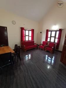 a room with red chairs and a table and windows at Wanders In Coffee Stays in Madikeri