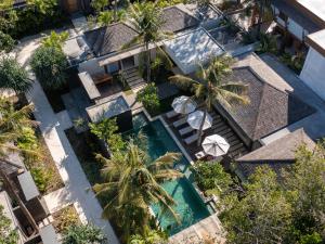 an overhead view of a swimming pool with palm trees at Cocana Resort Gili Trawangan in Gili Trawangan