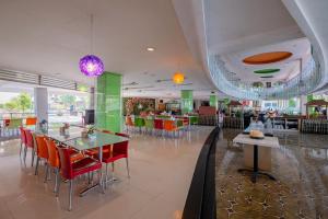 a restaurant with red chairs and tables in a building at RedDoorz Premium @ Jalan Veteran Bojonegoro in Bojonegoro