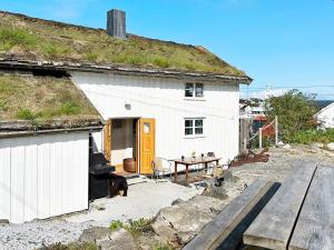 a white house with a grassy roof with a table at 7 person holiday home in Averøy-By Traum in Averoy