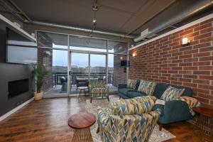 uma sala de estar com um sofá e uma parede de tijolos em Luxury Condo in Akron Northside District em Akron