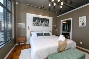 um quarto com uma grande cama branca e uma janela em Luxury Condo in Akron Northside District em Akron