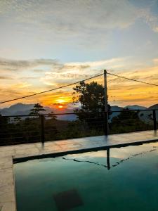 una piscina con tramonto sullo sfondo di The Aurelia a Gampola