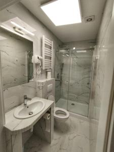 a bathroom with a toilet and a sink and a shower at Motel Tower in Toruń
