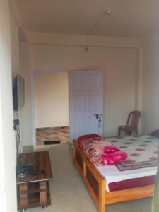 Zimmer mit einem Bett und einem Tisch in der Unterkunft DAMEKI GUEST HOUSE , Shillong in Shillong
