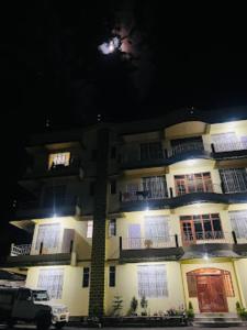 Un edificio di notte con una luna nel cielo di DAMEKI GUEST HOUSE , Shillong a Shillong