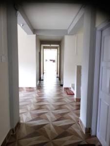 an empty hallway with a door and a tile floor at DAMEKI GUEST HOUSE , Shillong in Shillong