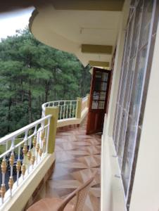 a balcony of a building with a view of trees at DAMEKI GUEST HOUSE , Shillong in Shillong