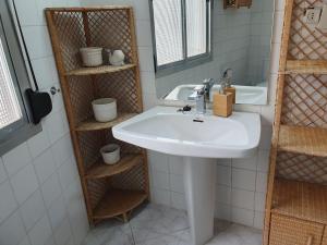 ein Badezimmer mit einem Waschbecken, einem Spiegel und Regalen in der Unterkunft Cozy Apartment toledo - Perfect for Families and Friends in Toledo