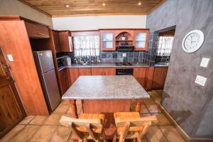 a kitchen with a table and chairs and a refrigerator at Butlers Crown in Klerksdorp