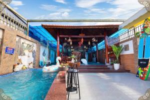 einem Pool vor einem Gebäude mit einem Haus in der Unterkunft Villages GOLD DAY Gần Biển Long Cung in Vũng Tàu