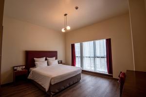 a bedroom with a bed and a large window at Aparthotel Adagio Fujairah in Fujairah