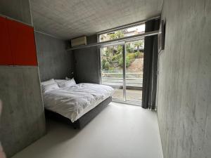 ein kleines Schlafzimmer mit einem Bett und einem Fenster in der Unterkunft art Ascona Design Attico in Ascona