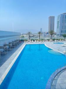 a large blue swimming pool on top of a building at Aparthotel Adagio Fujairah in Fujairah