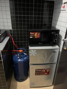 un forno a microonde in cima a un frigorifero in una cucina di The Hillmaac Nest 1 Eldoret a Eldoret