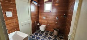 baño con aseo y paredes de madera en Luxe Villa by Hridhyam Group, en Dehradun
