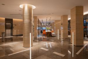 a lobby with a table and chairs and columns at Boudl Al Rawdah in Buraydah +26 photos