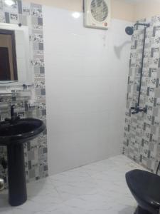 baño con lavabo y ventilador en The R Hotels en Karachi