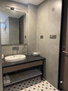 ein Bad mit einem Waschbecken und einem Spiegel in der Unterkunft The Deck in Jaipur