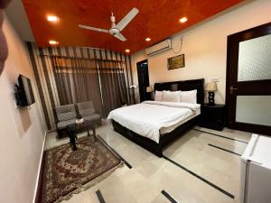 a bedroom with a bed and a ceiling fan at The R Hotels in Karachi
